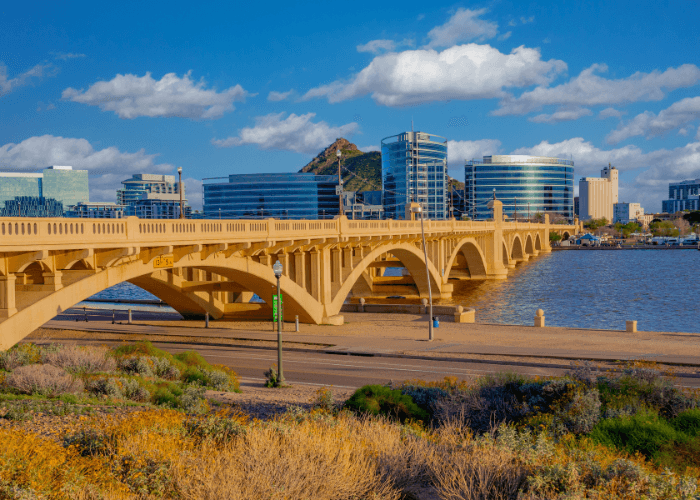 Tempe bridge with city buildings and blue sky in the background