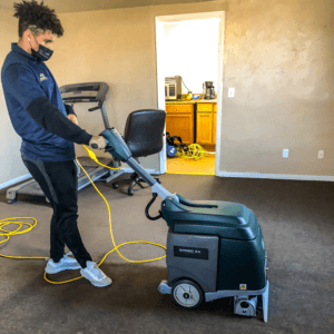Technician operating a heavy-duty carpet cleaning machine in a commercial building