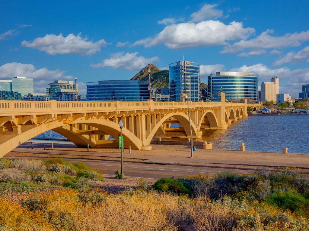 Tempe bridge with city buildings and blue sky in the background