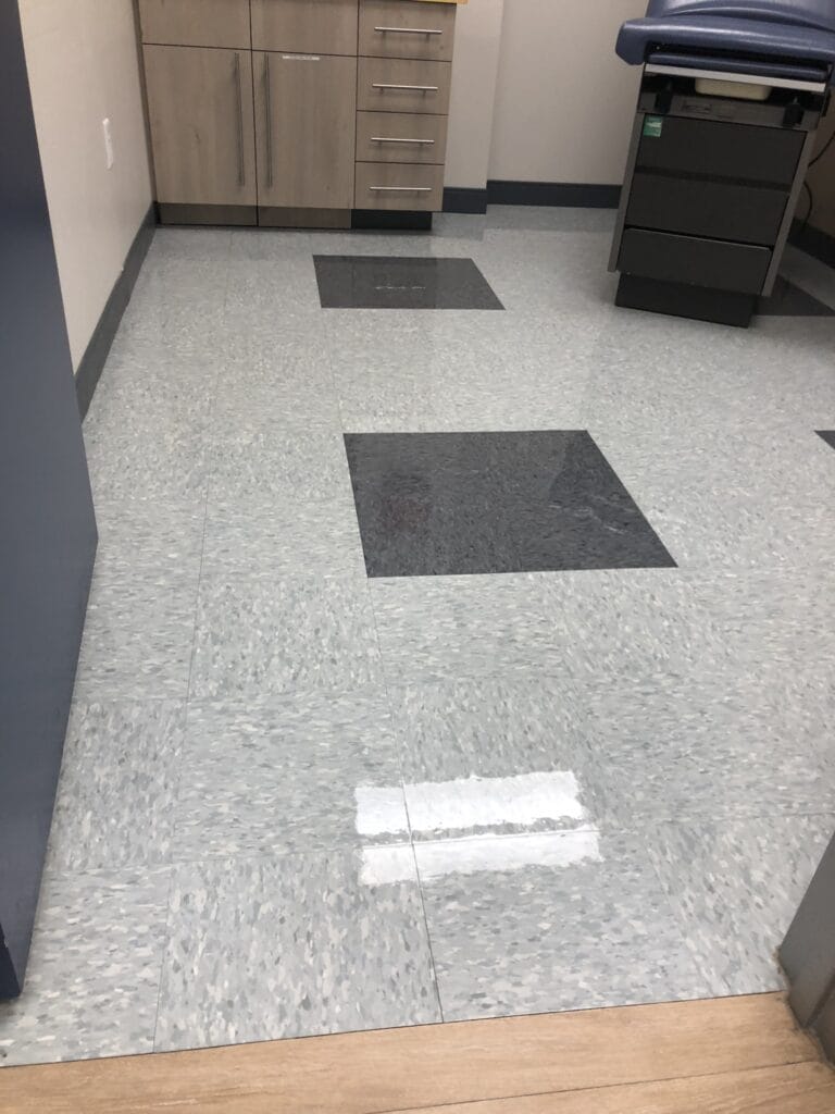 American Commercial Cleaning team member using a TruShot cleaner and microfiber cloth to disinfect and wipe down a table surface.
