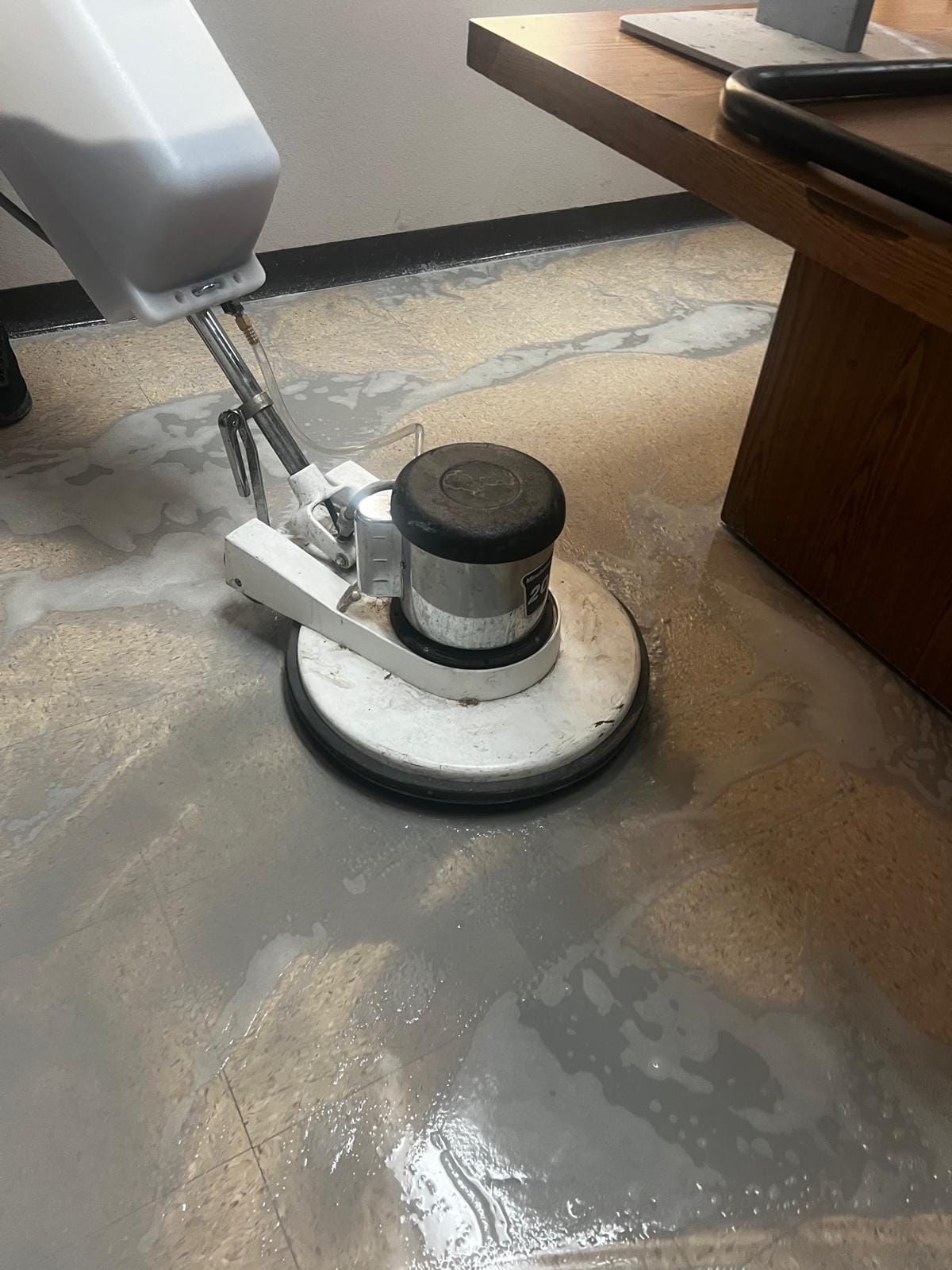 Floor buffer machine stripping old finish from tile flooring in preparation for waxing, performed by American Commercial Cleaning